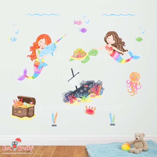 Part of the large mermaid fabric wall decals scene by Owl and Brolly. A close up view of 2 mermaids, the treasure chest, the ship wreck with fish, and other seaweeds and underwater creatures.