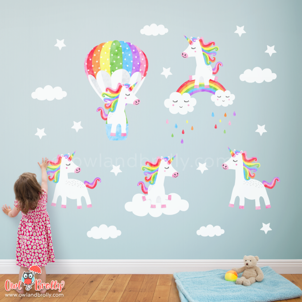 Unicorn wall art decals. 5 rainbow coloured unicorns on a removable and reusable fabric wall sticker, complete with clouds and stars. The perfect set for a coloured large wall in a playroom or nursery room.